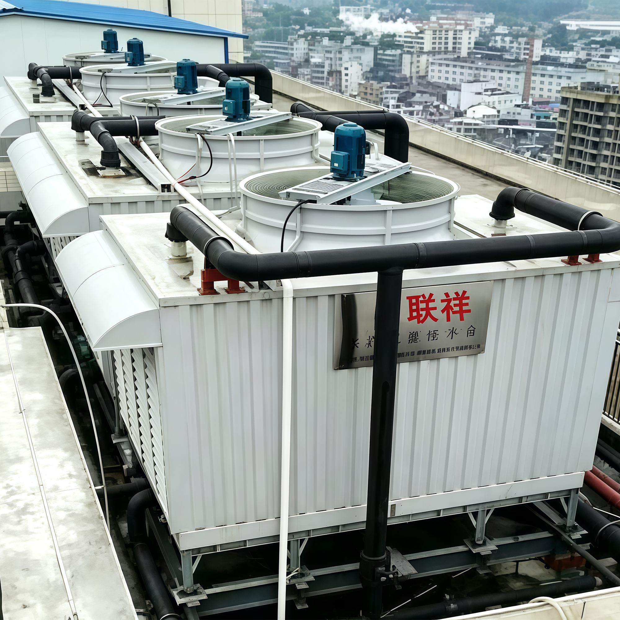 Multi-fan tower installation with insulated piping on a city rooftop
